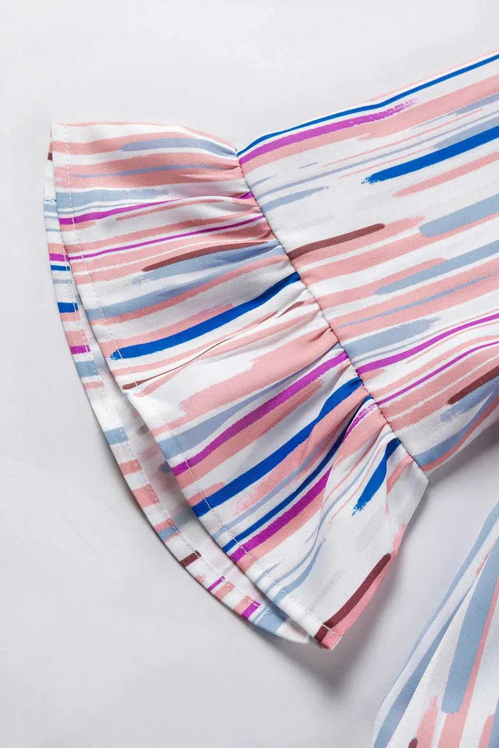 Close-up of the ruffled sleeve on the Rainbow Stripe Splash Blouse, emphasizing the colorful brushstroke design and feminine detail.