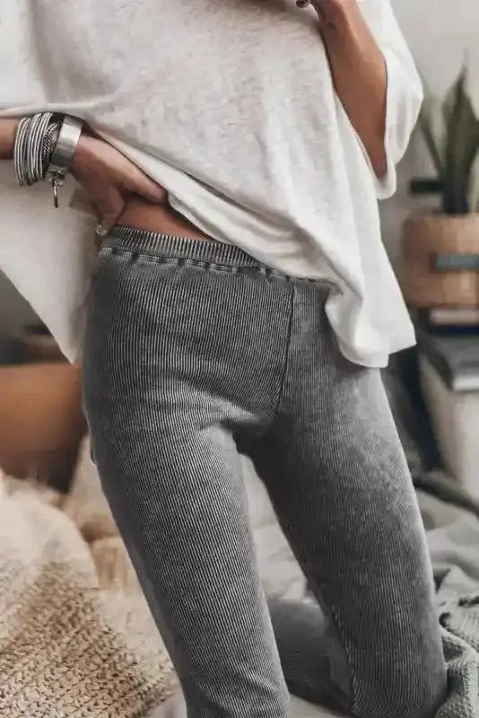 Dark grey ribbed leggings with vintage wash detail, paired with a loose white tee, highlighting the high-waisted fit and stretch fabric.