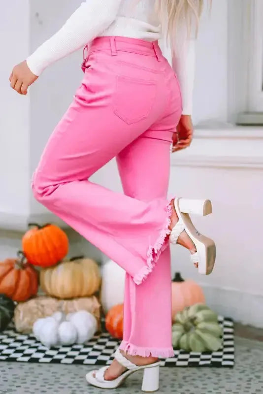 Back view of pink distressed high waist flare jeans showing raw hem detail Fashionfitz UK