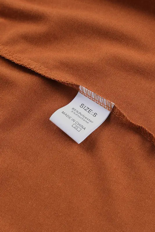 Clothing tag on waffle ruffle plus mini dress, size s, made in china, rust-colored fabric