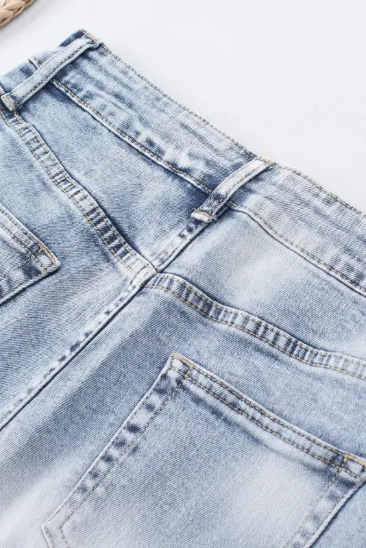 Washed distressed denim shorts: light blue jeans with visible pockets and stitching