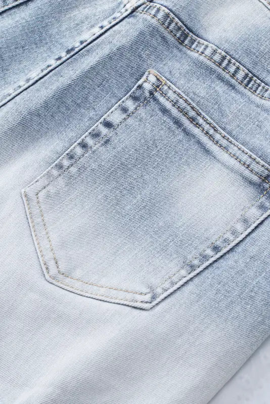 Close-up of back pocket on light-colored washed distressed denim shorts for a relax look