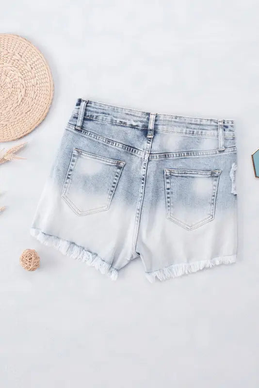 Washed distressed denim shorts with frayed edges and faded ombre effect for a relax look