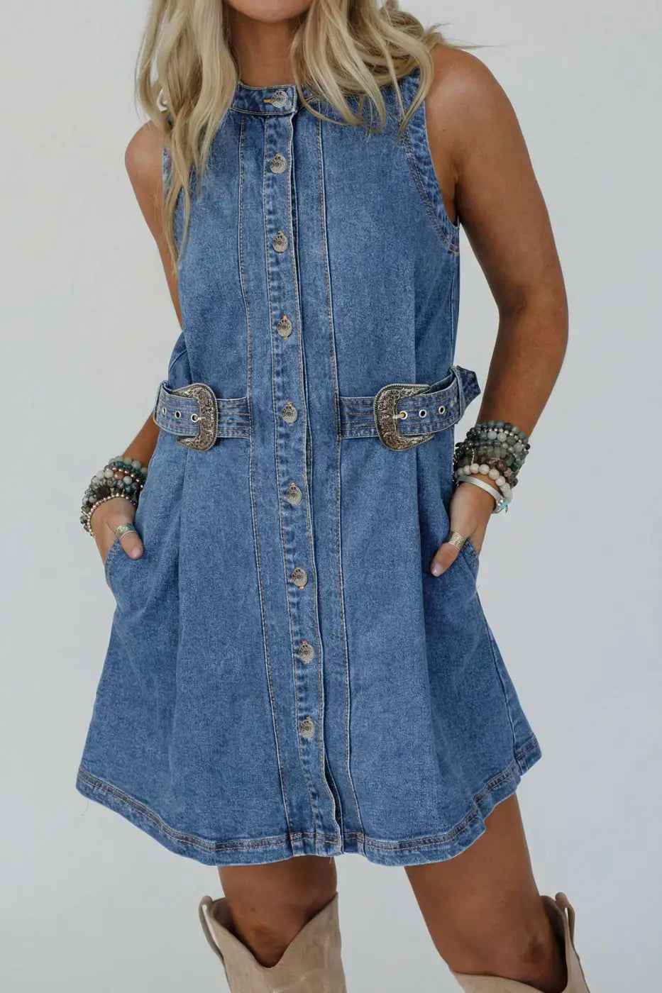 Western Belt Sleeveless Denim Dress styled with chunky bracelets and boots, highlighting the structured fit and belted waist for summer.