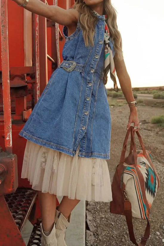 Layered look of Western Belt Sleeveless Denim Dress over a lace skirt, styled with a patterned bag and boots for a boho festival outfit.