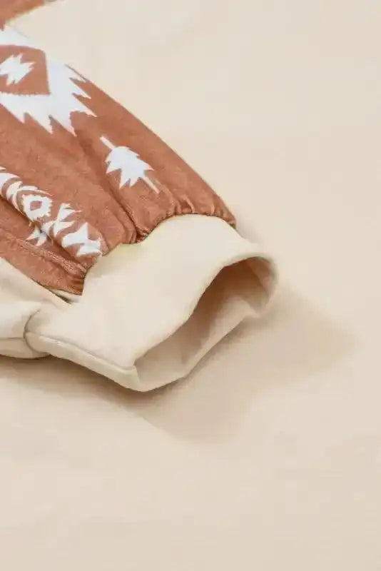 Close-up of Western Print Patch Long Sleeve Top cuff showing beige fleece fabric and brown Aztec print sleeve, ideal for casual winter wear.