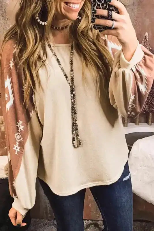 Close-up of Western Print Long Sleeve Top with fleece fabric and Aztec print sleeves, styled with layered necklaces for a boho look.