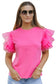 Whimsical wave blouse: bright pink top with ruffled tulle sleeves worn by a stylish woman