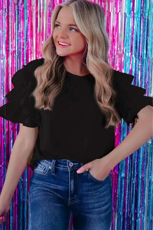 Smiling blonde woman in whimsical wave blouse with colorful streamers background