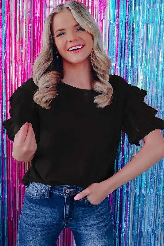 Smiling blonde woman in whimsical wave blouse against colorful tinsel backdrop, relax relax