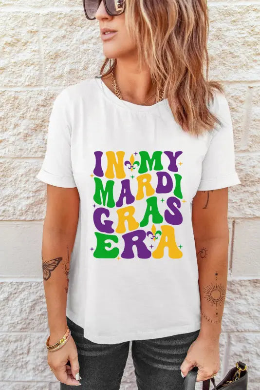 White crew neck t-shirt with ’in my mardi gras era’ text and festive designs