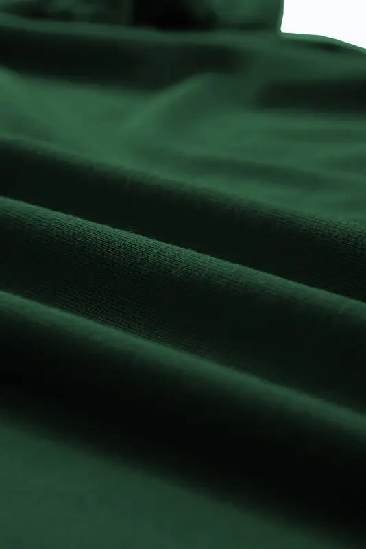 Soft, dark green fabric folds of a white casual plain crew neck t-shirt for ultimate relax