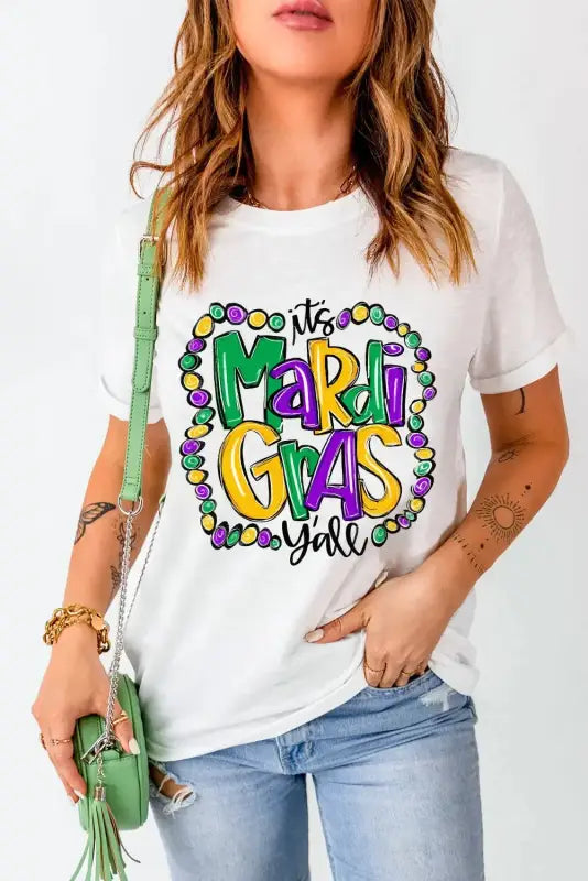 White crew neck t-shirt with colorful ’it’s mardi gras y’all’ design and beads