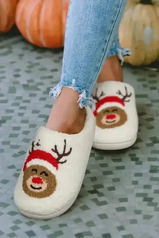 Front-facing white Christmas deer slippers with smiling reindeer design, fleece texture for warm and festive indoor comfort.