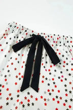 Close-up of pyjama pants waistband from White Star Panel Pyjama Set with black bow tie and red-black star print. Elastic waist for comfort.