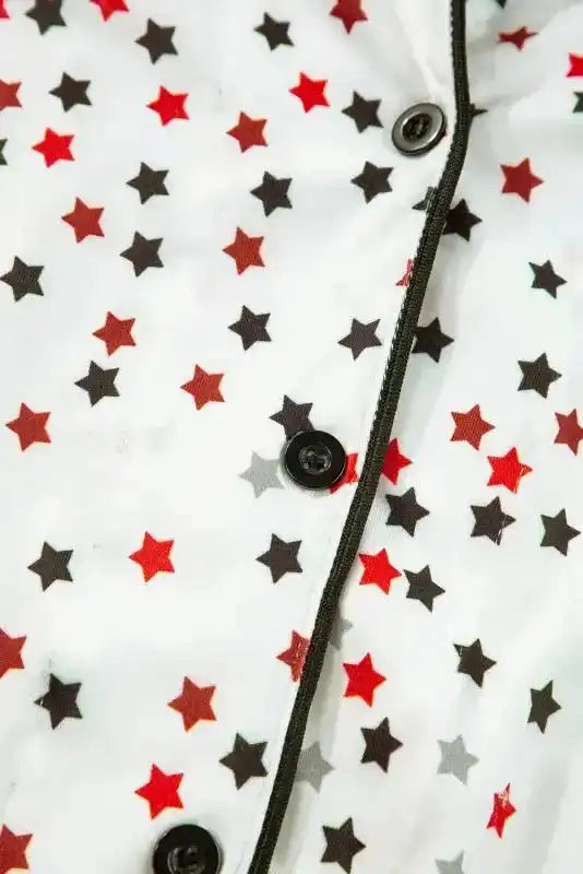 Zoomed-in view of buttoned front on White Star Panel Pyjama Set with red and black stars. Fine stitching and soft fabric for nightwear.