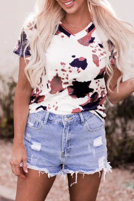 Woman in cow pattern print t-shirt and distressed denim shorts for a relax relax look