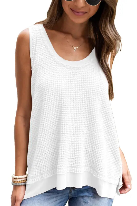 White flowy tunic tank top with textured waffle knit and layered hem for a relaxed look