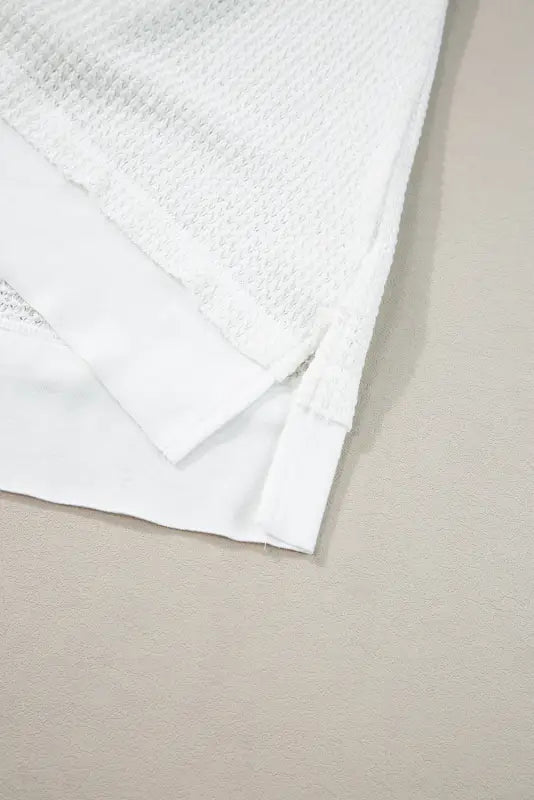 Close-up of a textured white cotton towel paired with a white flowy tunic tank top