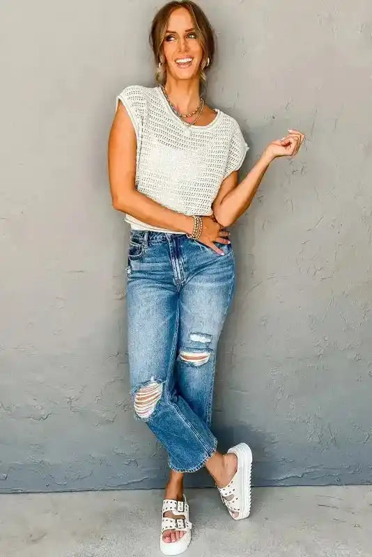 Full outfit view of woman wearing White Knit Tee with ripped jeans and sandals, ideal for a relaxed, casual day look.