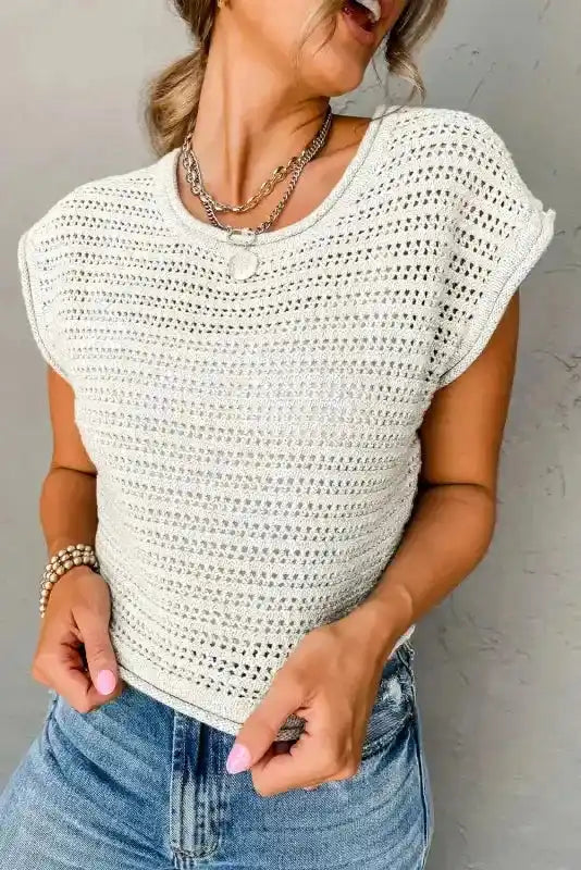 White Knit Tee with cap sleeves and hollow-out design styled with denim jeans, showcasing breathable crochet texture for casual wear.