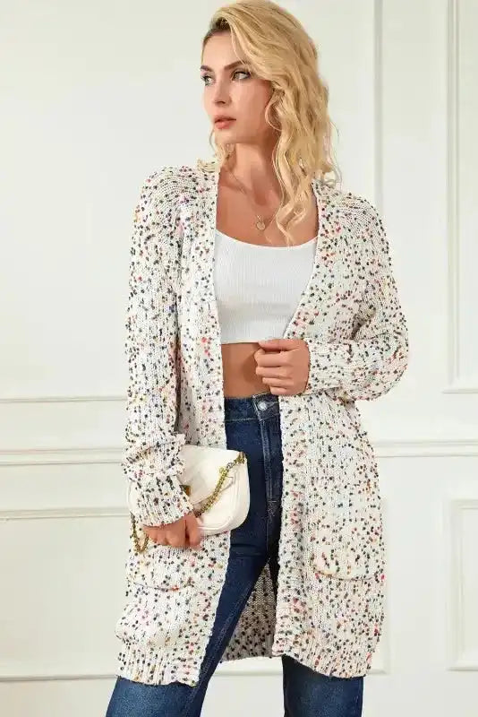 Side view of Patterned Sleeve White Sweater cardigan styled with a white purse and jeans, ideal for casual winter outings.