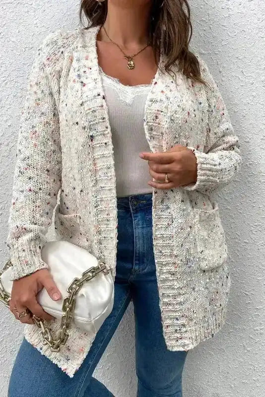 Close-up of White Pilling Detail Patterned Sleeve Sweater cardigan with front pockets and multicolor speckled knit, styled with a chain bag.