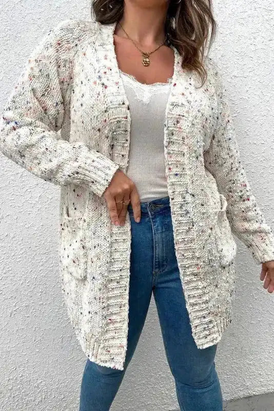 Model in Patterned Sleeve White Sweater cardigan with ribbed trim and cozy fit, styled with jeans and a lace-trimmed tank top.