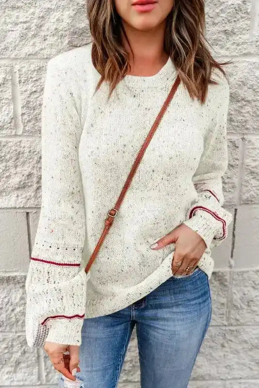 Patterned Sleeve White Sweater with loose fit and red stripe details, styled for a cozy and chic winter look.