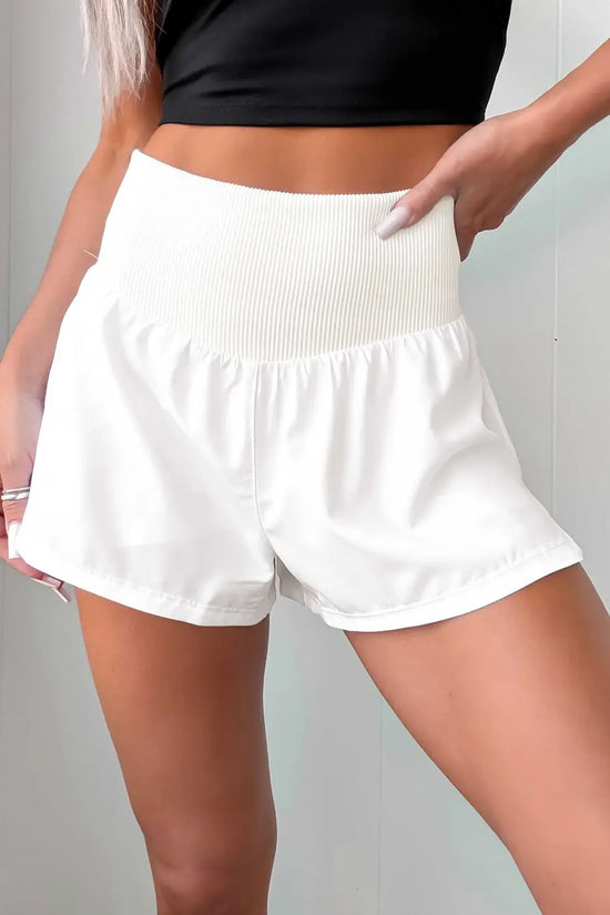 Front view of white ribbed high waist workout shorts for women, designed with solid color and breathable fabric for gym and fitness wear.
