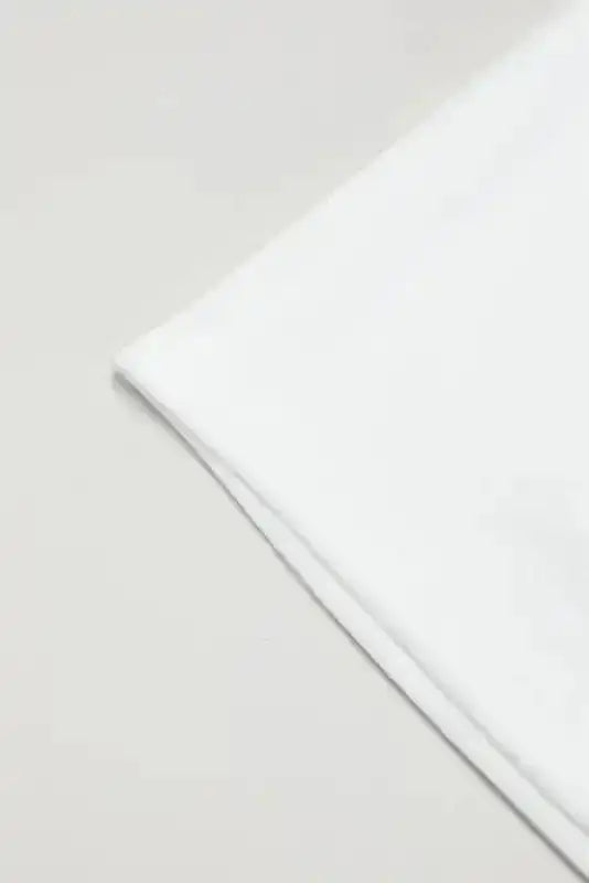 Hem detail of White Sequin Puff Sleeve Dress showcasing clean shift mini dress cut in elegant white fabric.