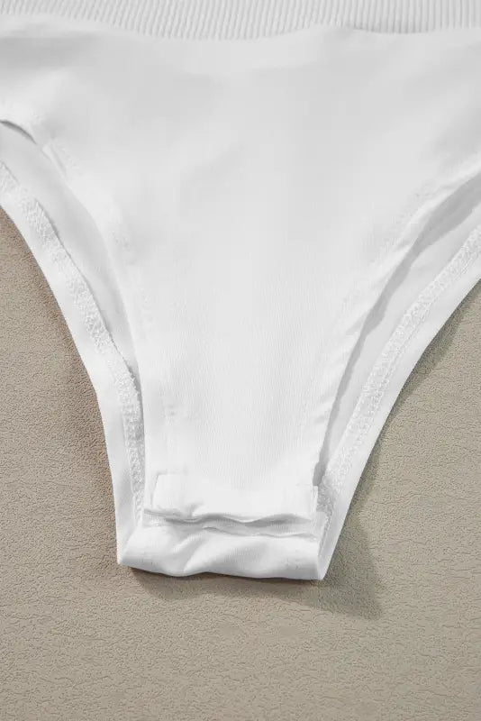 White cotton underwear or bikini bottom paired with a mock neck zip-up ribbed bodysuit