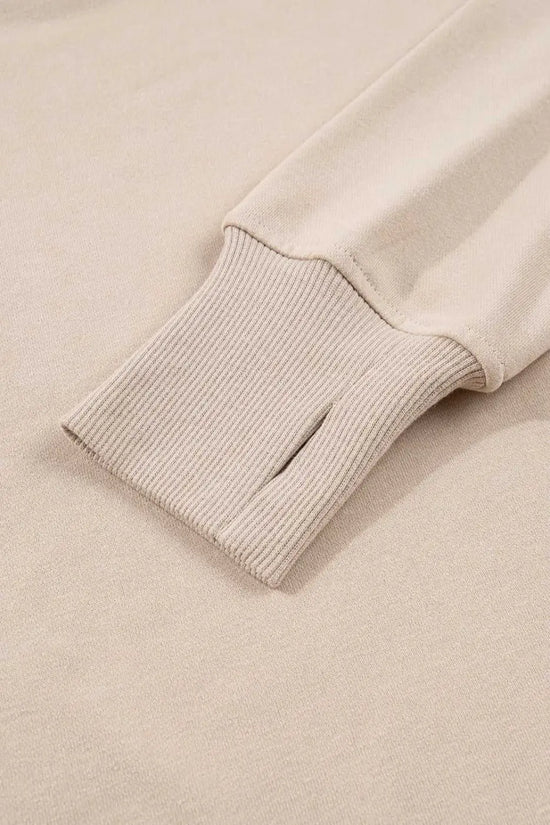 Close-up of ribbed cuff with thumbhole on beige Oversized Sweatshirt, part of the cozy and functional Matching Set for women.