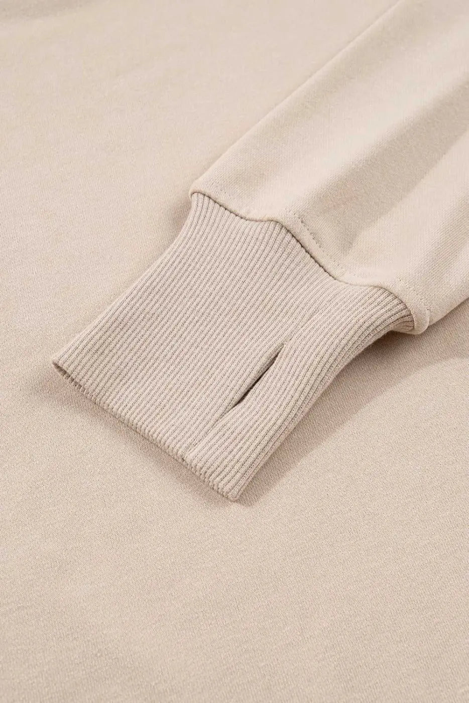 Close-up of ribbed cuff with thumbhole on beige Oversized Sweatshirt, part of the cozy and functional Matching Set for women.