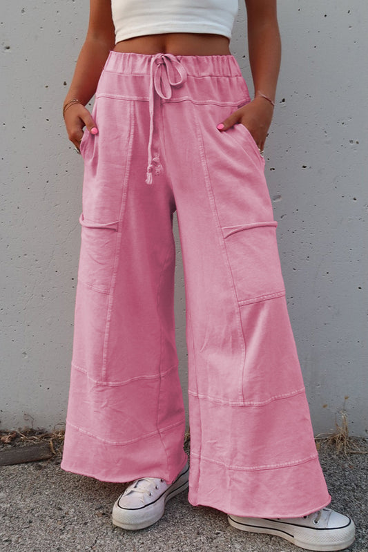 Pink women's wide leg cargo pants with large pockets and a drawstring waistband for comfort